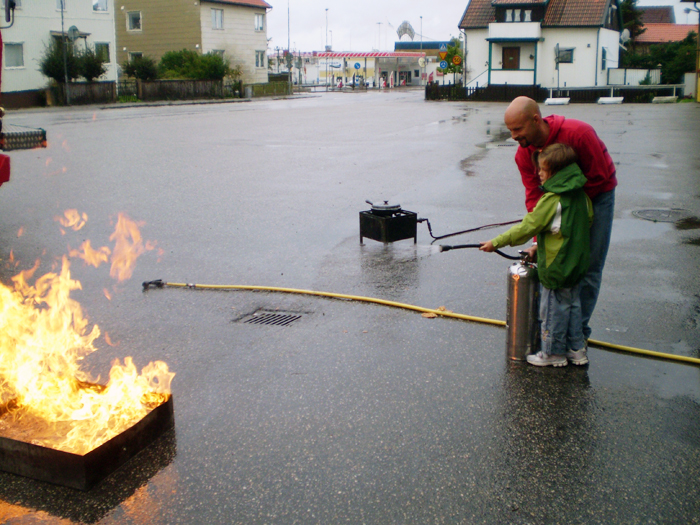 Brandman visar barn hur man släcker brand